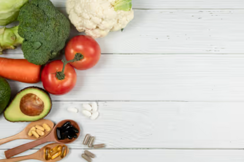 Verduras y suplementos sobre mesa blanca