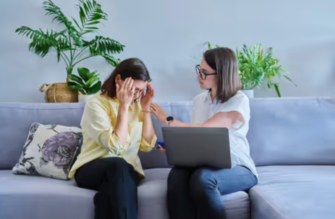 Female Psychologist And Middle Aged Woman Patient Sitting Together On Couch In Office Fotos, retratos, imágenes y fotografía de.png